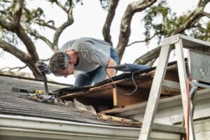 Homeowner inspecting a storm damaged roof in Des Moines, IA